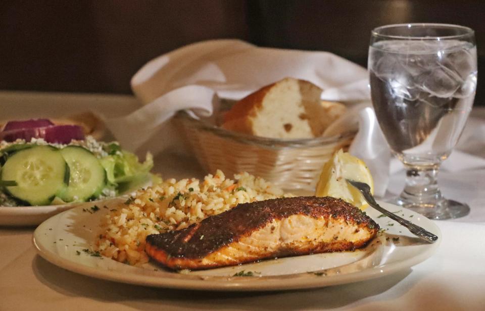 Blackend Salmon with rice pilaf and a side salad with house made creamy Gorgonzola dressing and dry bleu cheese crumbles at the Diamond Grille on Tuesday, Feb. 6, 2024 in Akron. The Salmon can be prepared broiled, blackened or chargrilled.