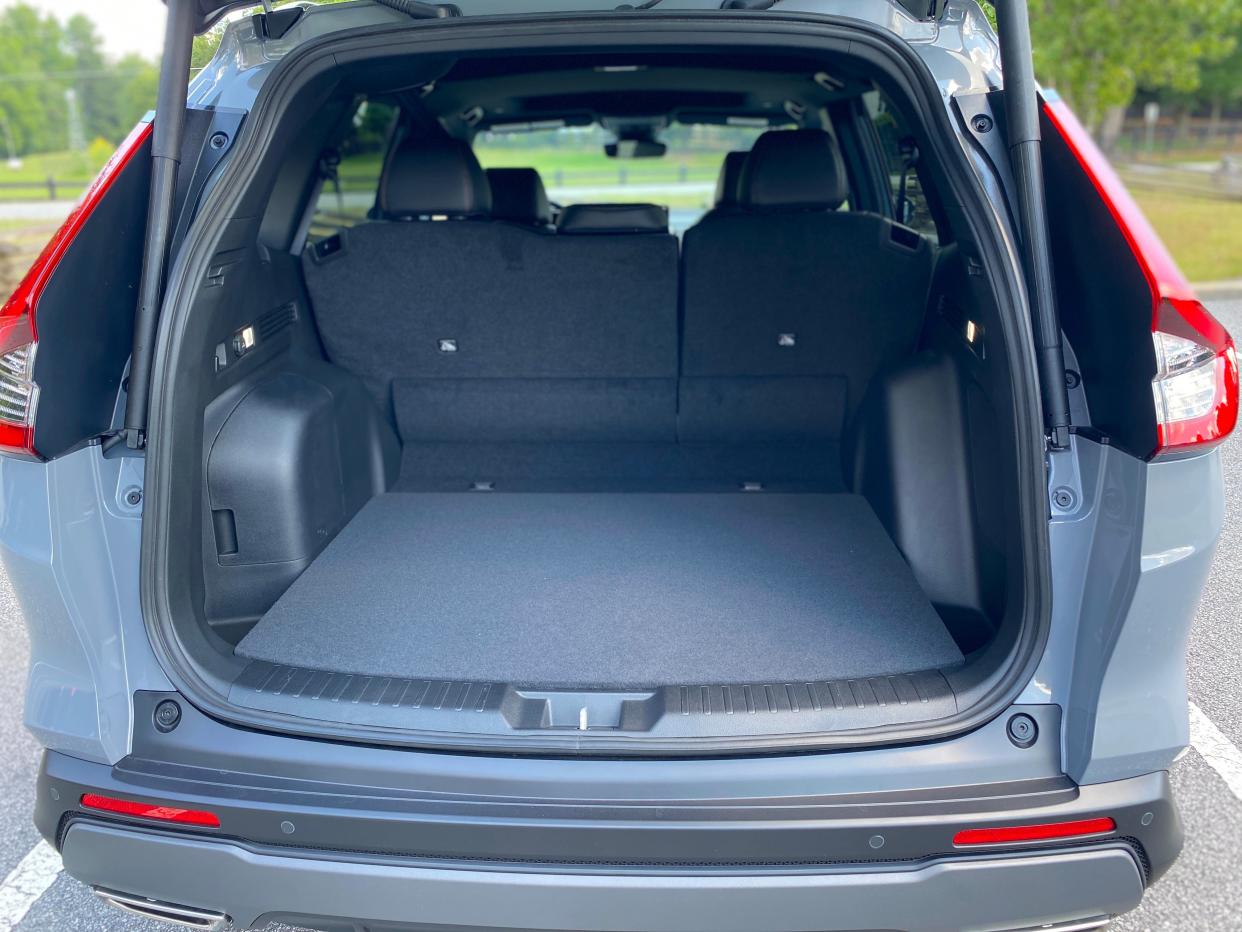 The rear cargo compartment behind the back seat of a gray 2025 Honda CR-V Hybrid SUV.