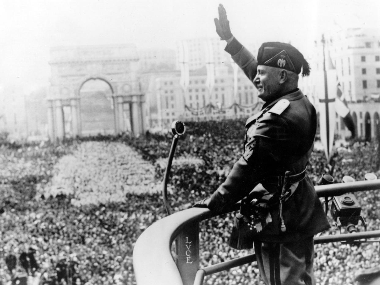 Benito Mussolini saluting during a public address: Getty