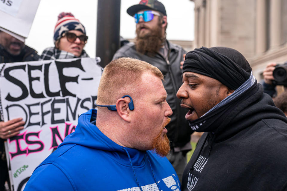 A supporter of Kyle Rittenhouse (L) argues with a Black Lives Matter supporter in front of the Kenosha County Courthouse while the jury deliberated. Source: Getty