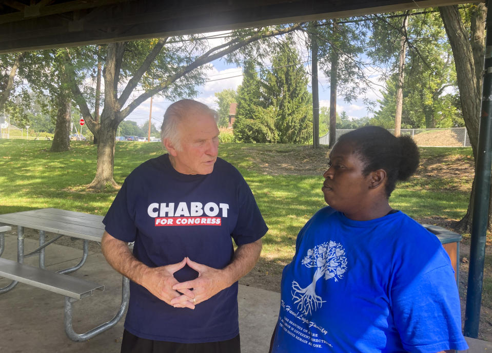 Rep. Steve Chabot, R-Ohio, talks with constituent Latesha Wilson, right, at a park in Reading, Ohio, Sunday, Sept. 18, 2022. Chabot has tried to tie his Democratic opponent, Cincinnati city council member Greg Landsman, to President Joe Biden, helping illustrate how some Democratic candidates are struggling with how much to embrace -- or distance themselves -- from the president ahead of November’s midterm elections. (AP Photo/Will Weissert)