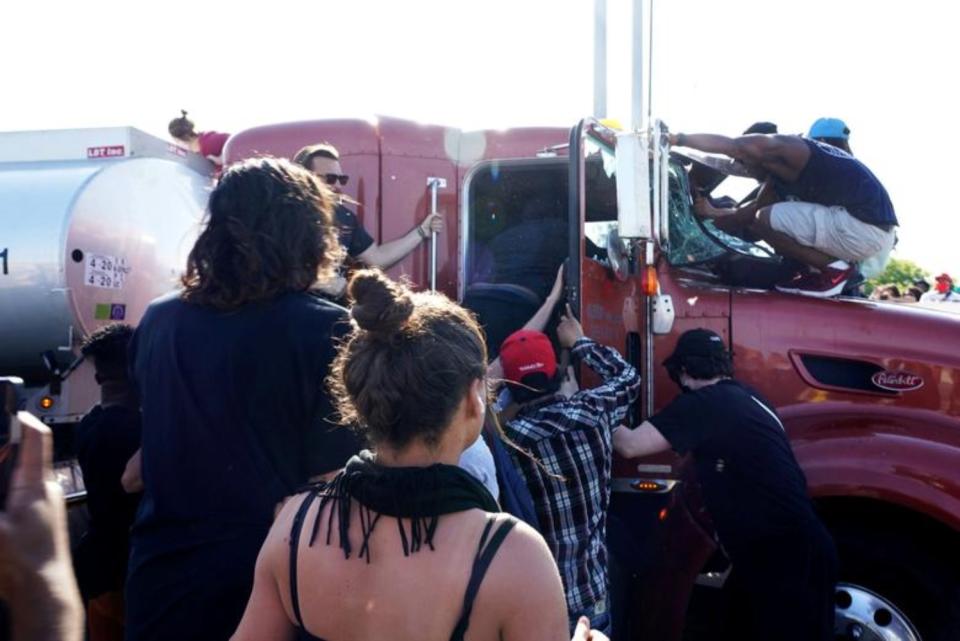 Varias personas se suben a la cabina del camión que embistió contra la manifestación de Minneapolis. (Foto: Go Nakamura / Reuters).