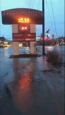 A sign for shops is seen as floodwaters flow along a street in Pullman, Washington, U.S. in this still image taken from April 9, 2019 social media video. ELLIE STENBERG/via REUTERS