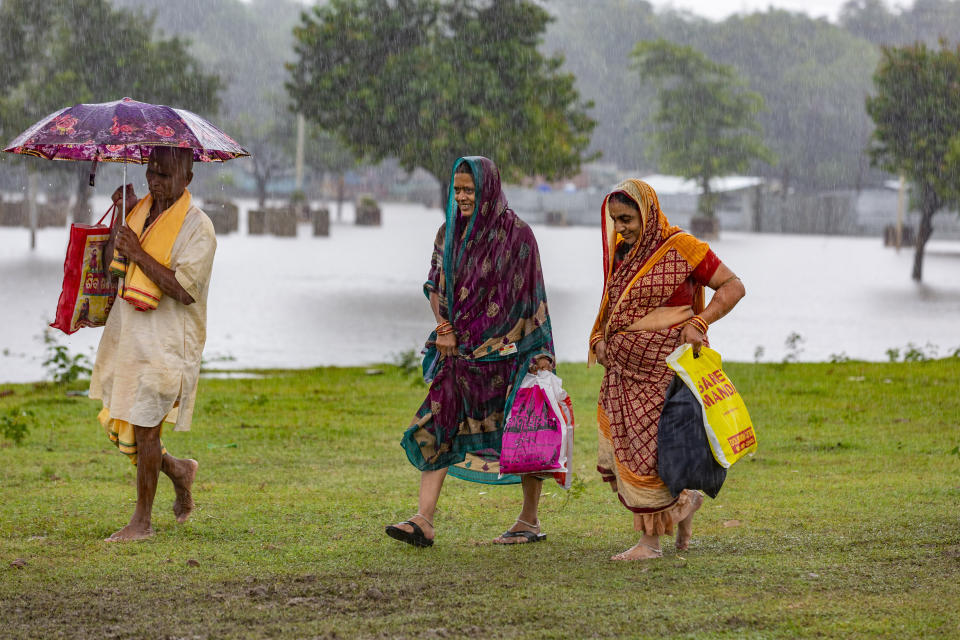 Hindu devotees return home in the rain in Prayagraj, in the northern Indian state of Uttar Pradesh, Saturday, Sept. 28, 2019. A heavy spell of retreating monsoon rains has flooded wide areas in northern India, killing dozens of people this week, an official said Saturday. Sandhaya Kureel, a spokeswoman of the Disaster Management and Relief Department, said most of the 59 fatalities were caused by house collapses, lightning and drowning in Uttar Pradesh state. (AP Photo/Rajesh Kumar Singh)