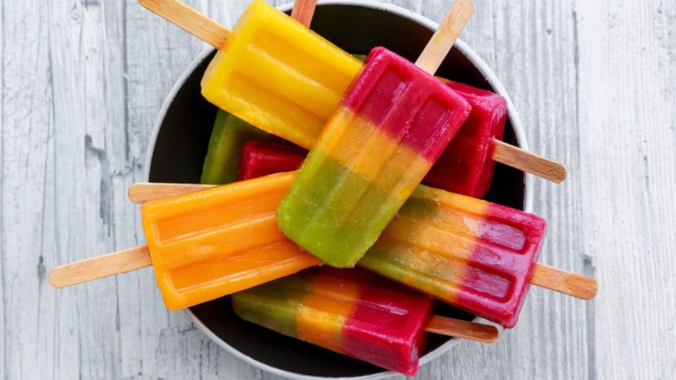 Ice lollies in various colours in a bowl