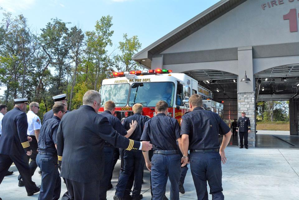 Columbia Fire Department staff take part in a truck housing Tuesday by ceremonially pushing a fire apparatus into station 11, which had its grand opening that day.