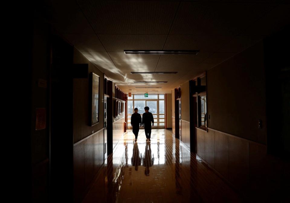 Empty feeling: Eita and Aoi walk along the corridor of their school (Reuters)