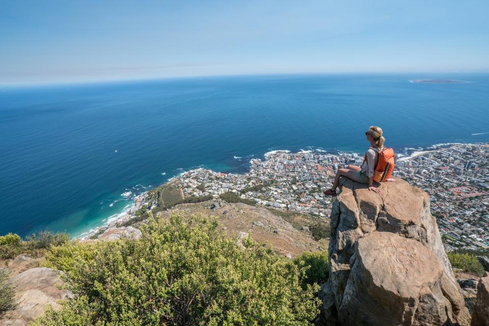 Young woman in Cape Town on top of mountain looking at view