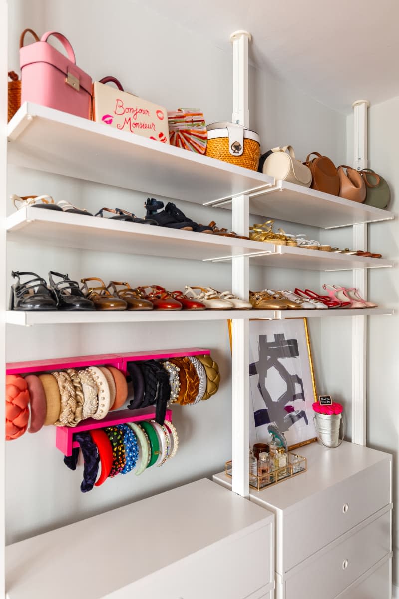 Storage for an assortment of shoes, purses, and other accessories is displayed on a white shelving.