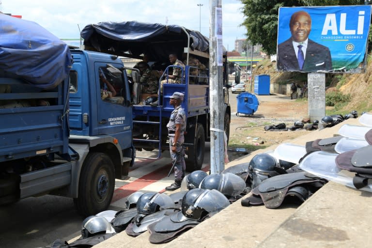 Gabonese security forces are seen deployed next to a campaign poster of President Ali Bongo in Libreville ahead of the Constitutional Court's announcement