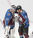 Colorado Avalanche goalie Philipp Grubauer (31) and teammate Cale Makar (8) celebrate the team's win over the Arizona Coyotes in Game 1 of an NHL hockey Stanley Cup first-round playoff series, Wednesday, Aug. 12, 2020, in Edmonton, Alberta. (Jason Franson/The Canadian Press via AP)