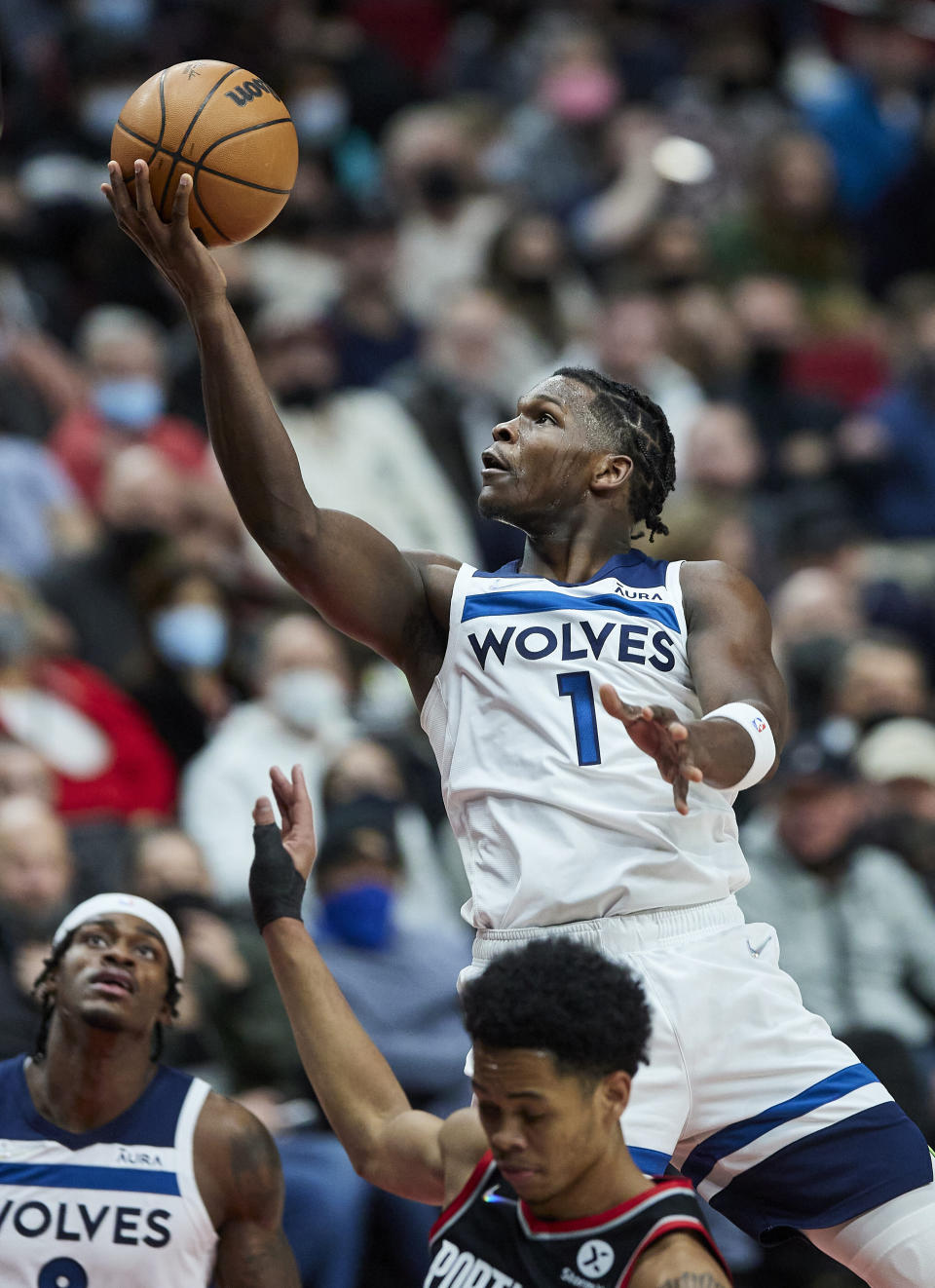 Minnesota Timberwolves forward Anthony Edwards shoots over Portland Trail Blazers guard Anfernee Simons during the first half of an NBA basketball game in Portland, Ore., Tuesday, Jan. 25, 2022. (AP Photo/Craig Mitchelldyer)