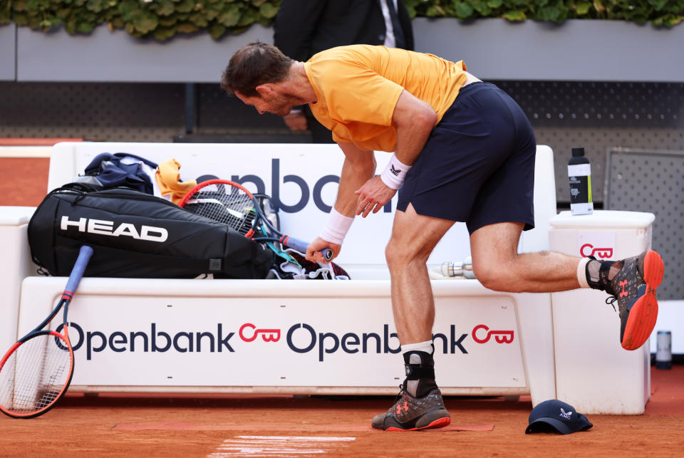 Andy Murray smacks his racquet against his bag.