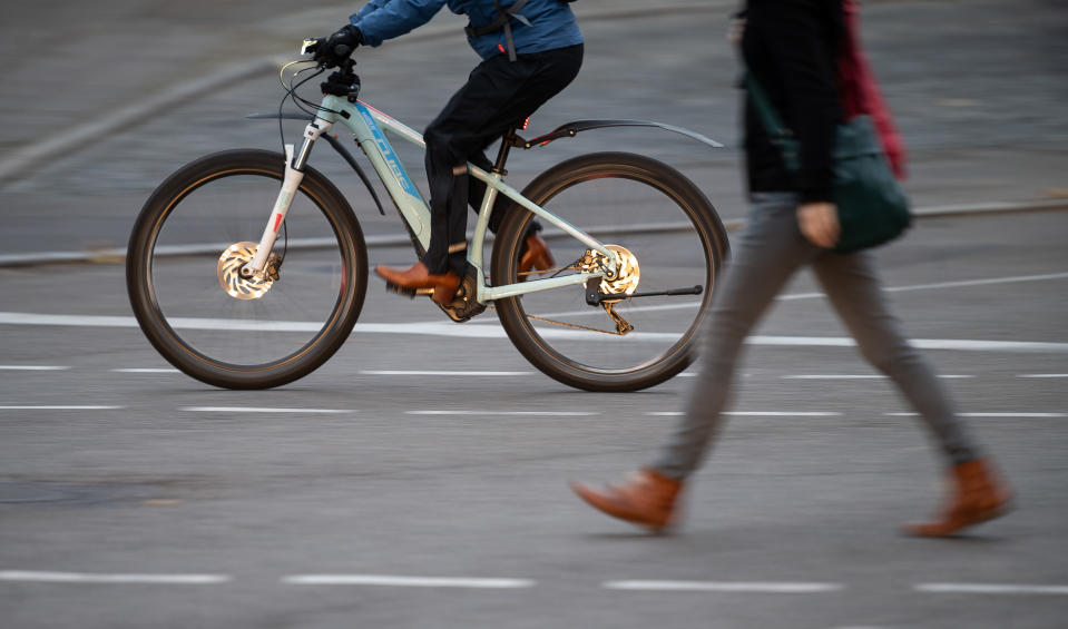 An e-bike rider overtakes a pedestrian in morning traffic in Baden-Wuerttemberg, Stuttgart, Germany. Photo: Sebastian Gollnow/Picture Alliance via Getty