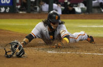 San Francisco Giants' Brandon Crawford slides safely into home scoring their first run against the Arizona Diamondbacks during the fourth inning of a baseball game, Saturday Sept. 24, 2022, in Phoenix. (AP Photo/Darryl Webb)