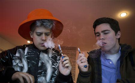 Customers puff on e-cigarettes at the Henley Vaporium in New York City December 18, 2013. REUTERS/Mike Segar