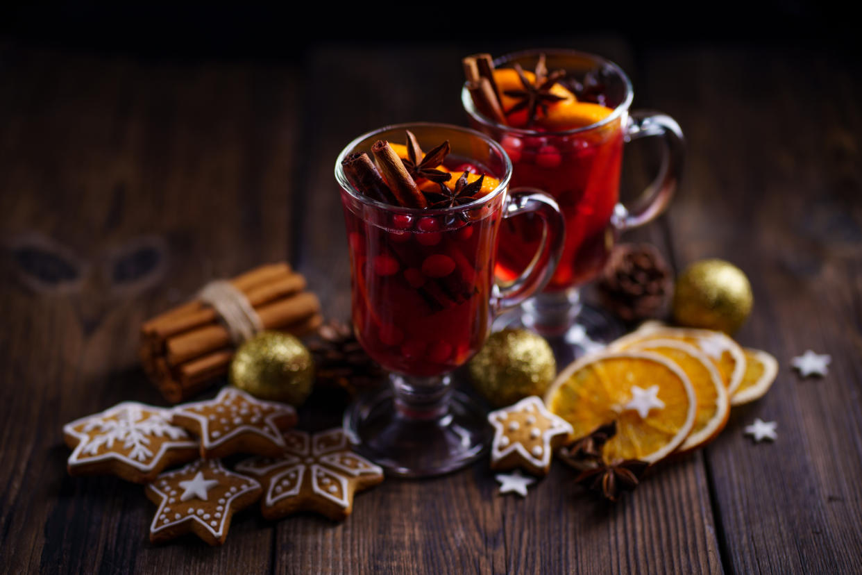 Christmas holidays atmosphere, cold winter day. Warming mood. Mulled wine with cranberry, cinnamon, orange and anise.