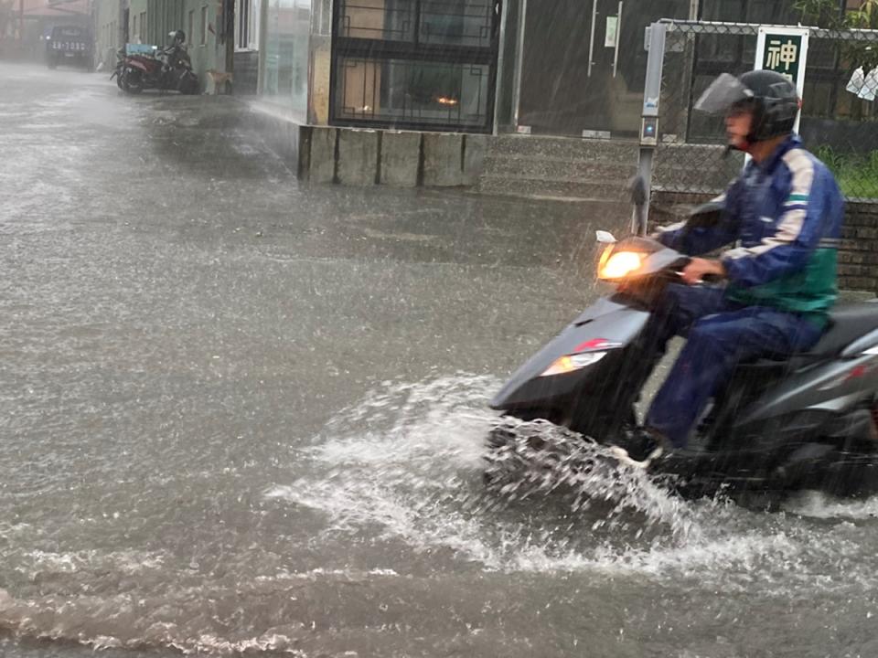 高雄市區22日有間歇性大雨，上班尖峰時間降雨不斷， 鳥松區神農路一帶積水約半個輪胎深，騎士一早水中行 備感不便。 （民眾提供） 