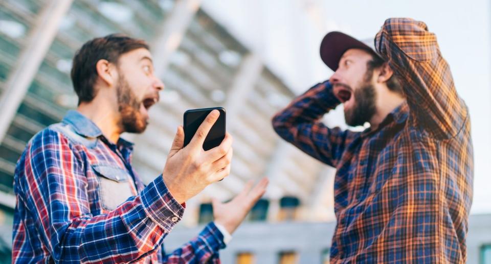 Two men exclaim excitedly while looking at each other. Source: Getty Images