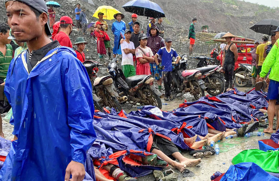 Un grupo de personas se congrega junto a los cuerpos de las víctimas de un deslave cerca de una mina de jade en Hpakant, en el estado de Kachine, en el norte de Myanmar, el 2 de julio de 2020. (AP Foto/Zaw Moe Htet)