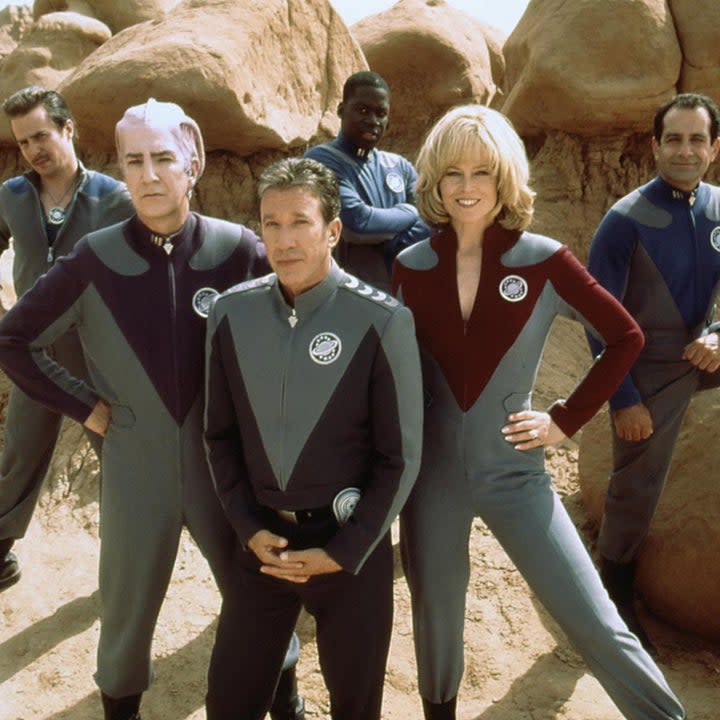 A group of space rangers stand together, smiling