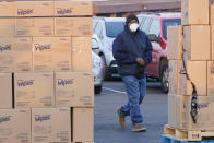 A man walks past pallets of disinfecting wipes as he arrives at Ebenezer Baptist Church for a COVID-19 vaccine, Jan. 26, 2021, in Oklahoma City. Rev. Derrick Scobey, Ebenezer Baptist Church Senior Pastor helped to organize the event in an effort to encourage more African Americans in Oklahoma City to receive the vaccine. (AP Photo/Sue Ogrocki)