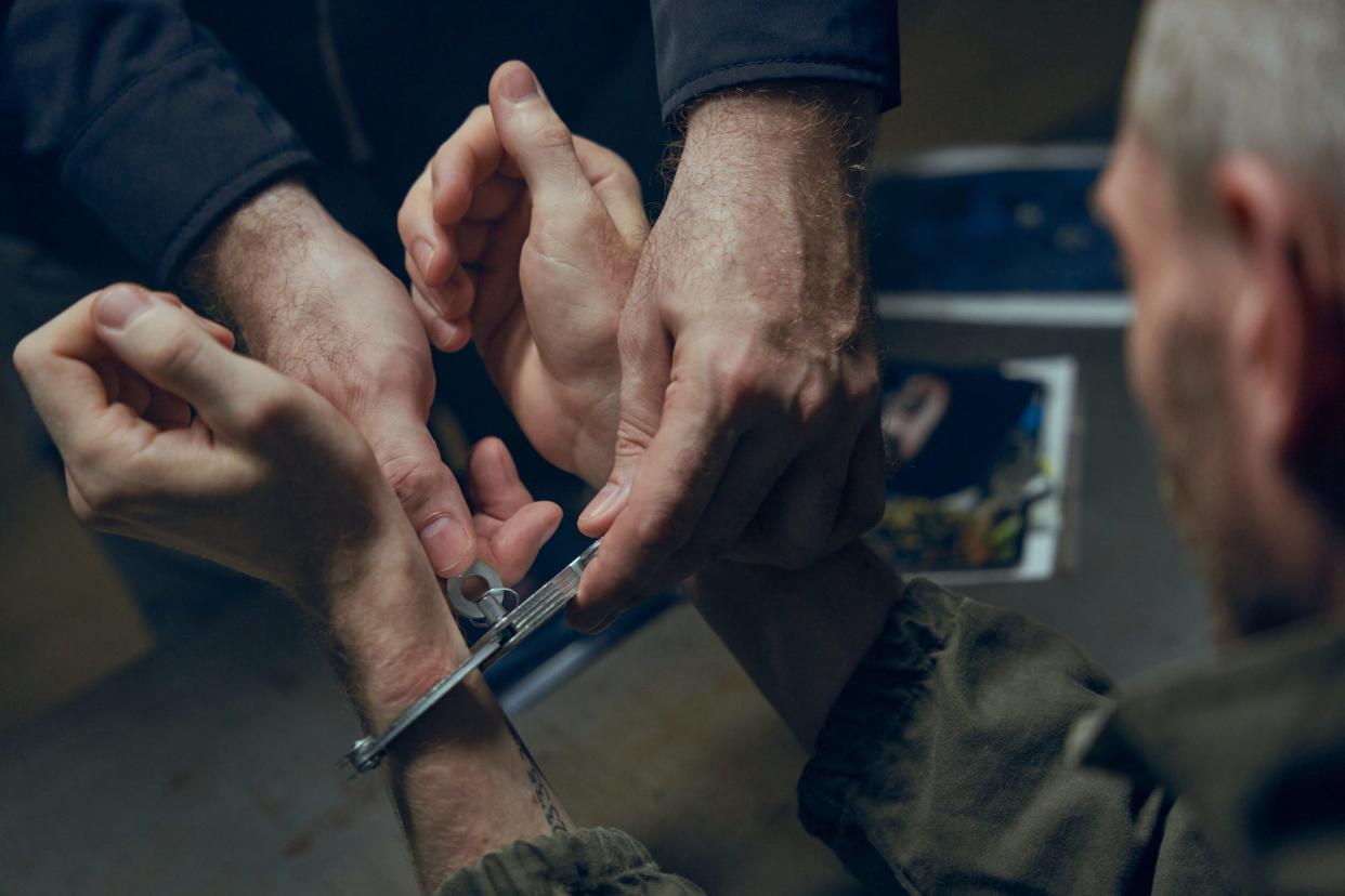 An officer removing handcuffs from criminal's hands