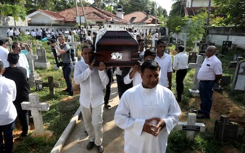 A coffin of a victim is carried during a mass burial of victims at a cemetery near St. Sebastian Church in Negombo. - Credit: ATHIT PERAWONGMETHA/&nbsp;REUTERS