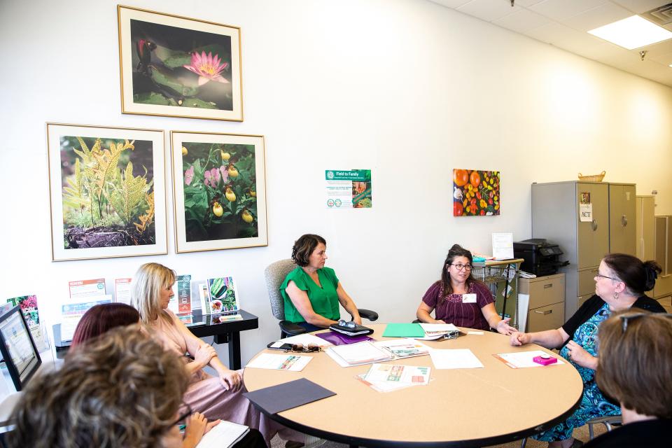 Michelle Kenyon, director of Field to Family, second from right, and Theresa Greenfield, USDA Rural Development State Director in Iowa, center, participate in a round-table discussion with Alison Demory of the Iowa City Community School District and Debbie Klein of the Clear Creek Amana School District on Sept. 15 in Pepperwood Plaza in Iowa City.