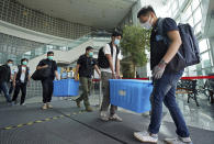 Police remove evidence from inside the Apple Daily newspaper headquarters after media tycoon and the newspaper's founder Jimmy Lai, who founded local newspaper Apple Daily, is arrested by police officers at his home in Hong Kong, Monday, Aug. 10, 2020. Hong Kong police arrested Lai and raided the publisher's headquarters Monday in the highest-profile use yet of the new national security law Beijing imposed on the city after protests last year. (Apple Daily via AP)