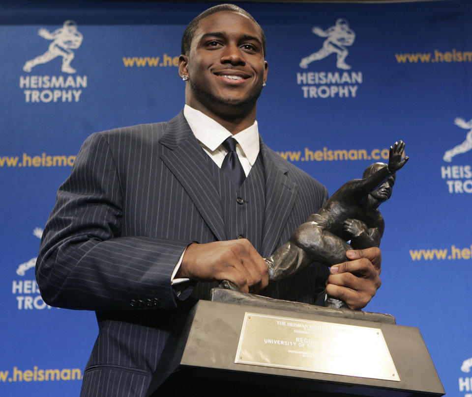 Reggie Bush segura o troféu Heisman durante uma entrevista coletiva em 10 de dezembro de 2005. Ele foi reintegrado como vencedor do Troféu Heisman de 2005 na quarta-feira.  (AP/Frank Franklin II)