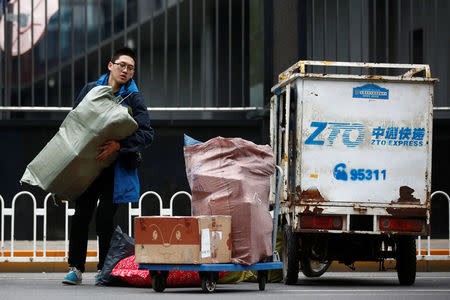 A man unloads parcels from a vehicle of a ZTO Express delivery in Beijing, China, October 27, 2016. REUTERS/Thomas Peter