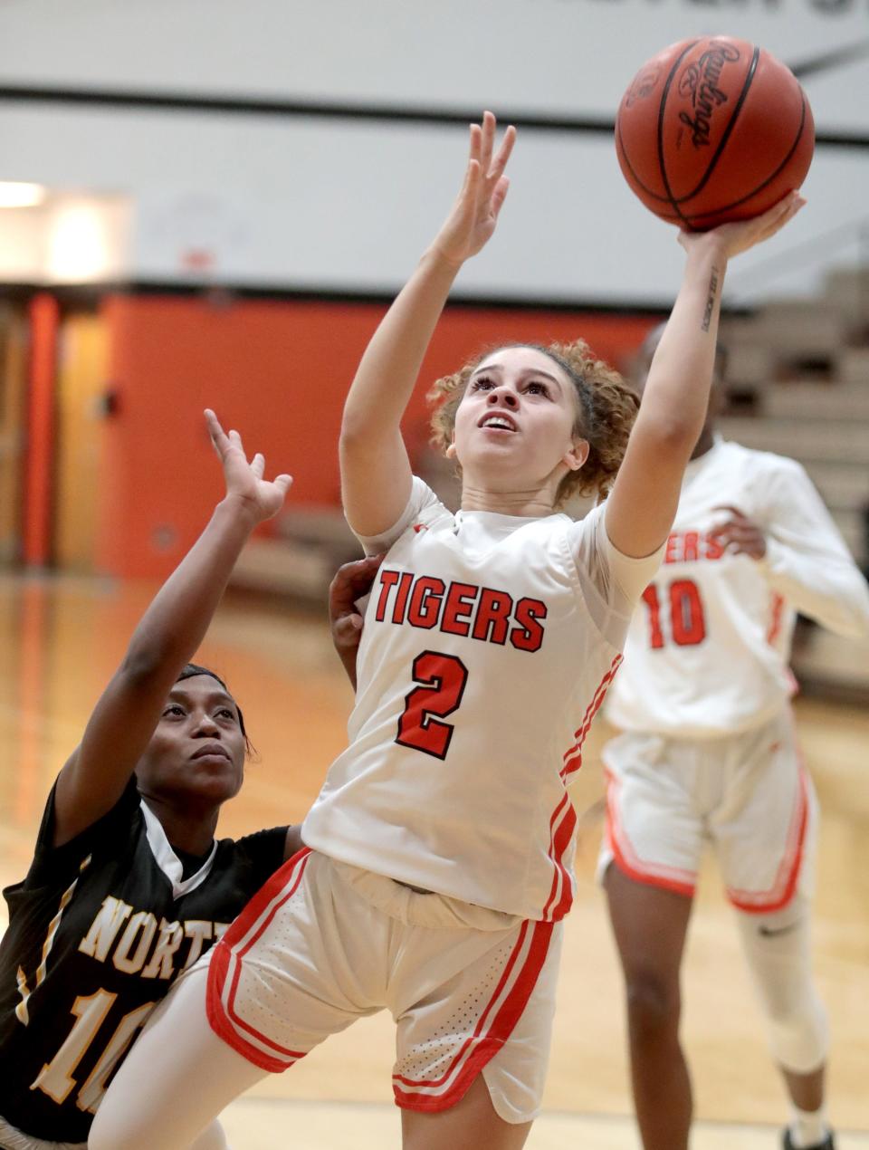 Massillon's Alana Settles goes to the hoop with pressure from Akron North's Shukuru Kalenga during Monday's game.