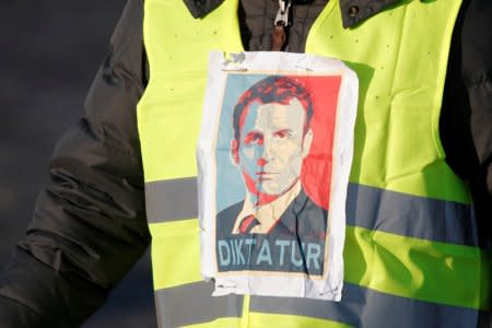 A man wearing a yellow vest, a symbol of a French drivers' protest against higher fuel prices, attends the demonstration with an image of French president Emmanuel Macron, in Paris, France, November 17, 2018. REUTERS/Charles Platiau