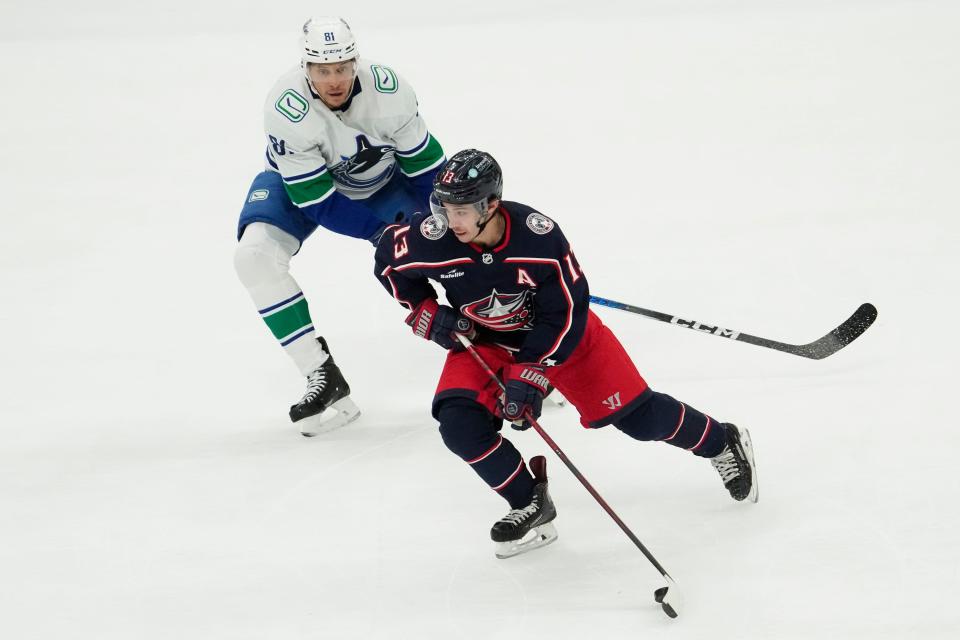 Jan 15, 2024; Columbus, Ohio, USA; Columbus Blue Jackets left wing Johnny Gaudreau (13) skates around Vancouver Canucks center Dakota Joshua (81) during the second period of the NHL hockey game at Nationwide Arena.