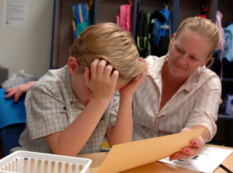 At brand-new New Berlin Elementary School, Seth Joyner, 6, resists his mother Gloria's attempts to cheer him up before she leaves his kindergarten class on the first day of school in 2006.