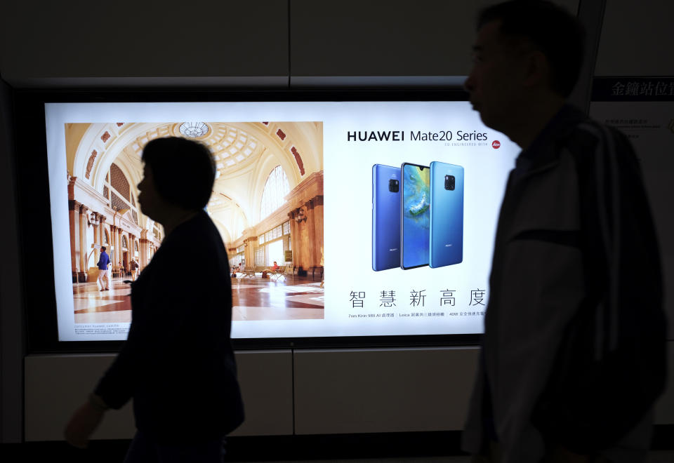 People walk past an advertisement for Huawei at a subway station in Hong Kong Thursday, Dec. 5, 2018. Canadian authorities said Wednesday that they have arrested Huawei's chief financial officer Meng Wanzhou for possible extradition to the United States. (AP Photo/Vincent Yu)