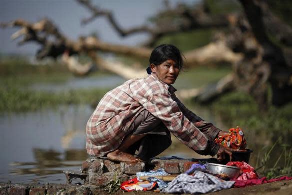 A woman washes clothes at a river in the outskirts of capital Naypyitaw, January 24, 2012.