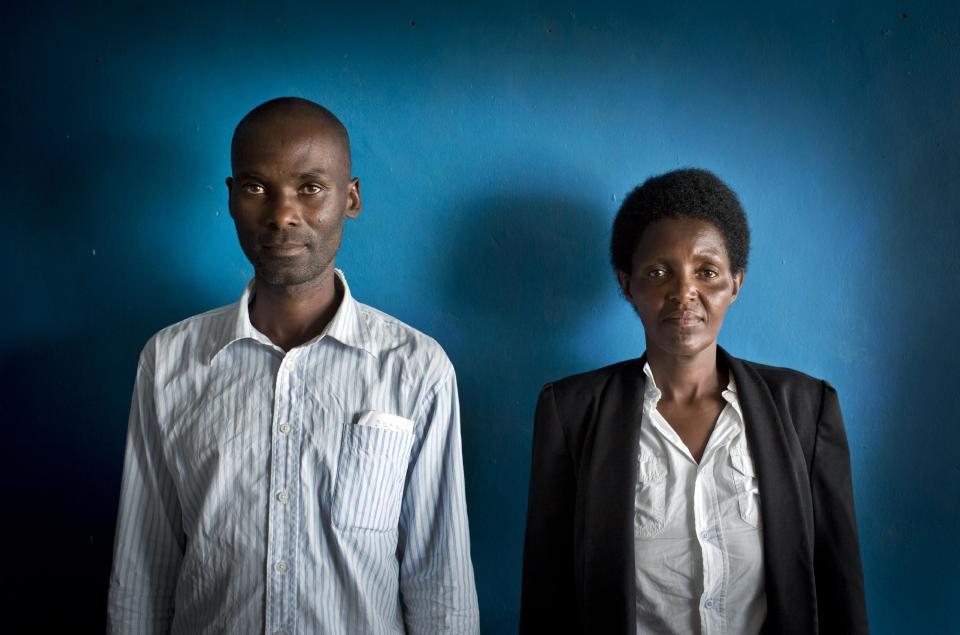 In this photo taken Wednesday, March 26, 2014, Emmanuel Ndayisaba, left, who during the 1994 Rwandan genocide cut off with a machete the hand of Alice Mukarurinda, right, in the swamp where she was hiding and killed her baby girl, but who are now friends, pose for a photograph at Alice's house in Nyamata, Rwanda. Although Rwanda has made significant progress since the genocide, ethnic tensions remain. (AP Photo/Ben Curtis)