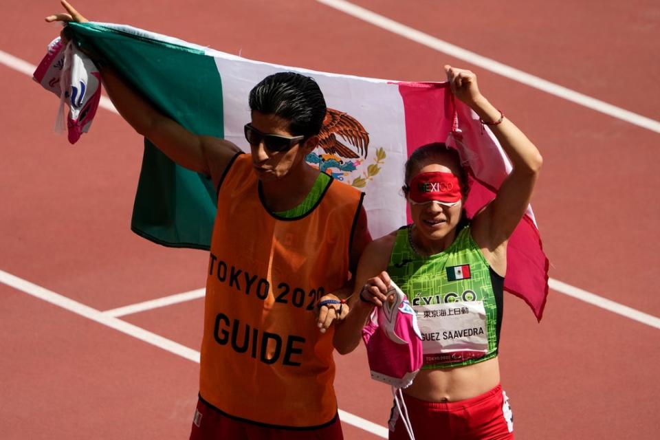 La mexicana Mónica Olivia Rodríguez Saavedra, derecha, y su guía, Kevin Teodoro Aguilar Pérez, celebran durante los 1500m T11 femeninos de los Juegos Paralímpicos de 2020 en el Estadio Nacional de Tokio, el lunes 30 de agosto de 2021. (AP/Eugene Hoshiko)