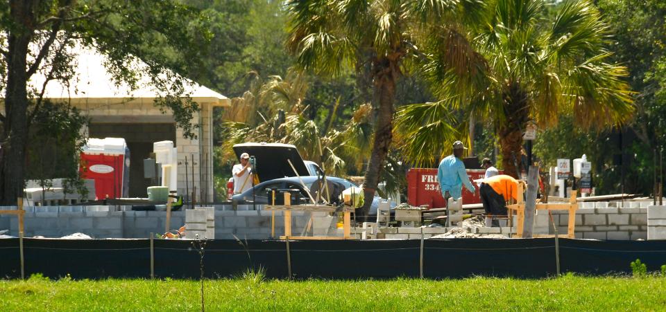 A construction team works on a home in the Aripeka neighborhood of Viera, where the custom builders aim to tailor homes to each property’s existing trees.