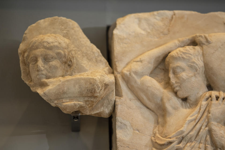 A newly placed male head, left, is seen on a frieze of the Acropolis museum during a ceremony for the repatriation of three sculpture fragments, in Athens, on Friday, March 24, 2023. Greece received three fragments from the ancient Parthenon temple that had been kept at Vatican museums for two centuries. Culture Ministry officials said the act provided a boost for its campaign for the return of the Parthenon Marbles from the British Museum in London. (AP Photo/Petros Giannakouris)