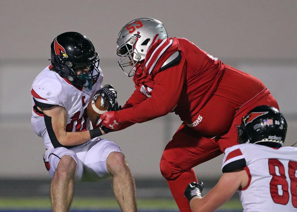 Canfield running back Scottie Eaton, left, is brought down by East defensive lineman Nicholas Hopfe during the first half of a Division III playoff football game Friday in Akron.