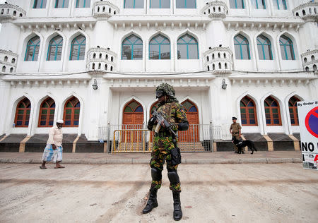 FILE PHOTO: Sri Lankan Special Task Force soldiers stand guard in front of a mosque as a Muslim man walks past him during the Friday prayers at a mosque, five days after a string of suicide bomb attacks on Catholic churches and luxury hotels across the island on Easter Sunday, in Colombo, Sri Lanka April 26, 2019. REUTERS/Dinuka Liyanawatte/File Photo