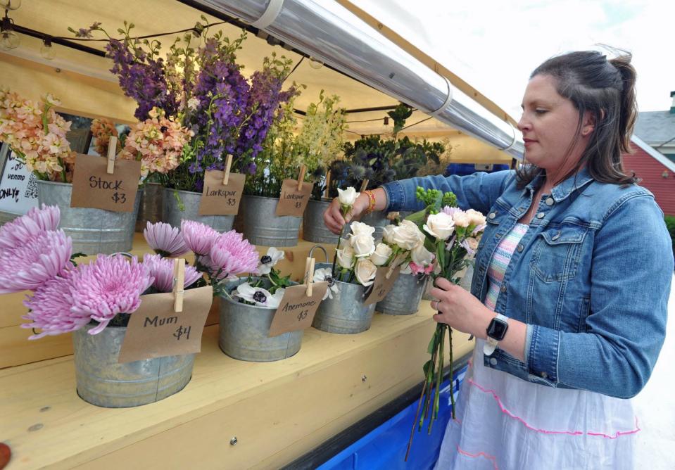 Megh Burgess, of Duxbury, owner of The Petal Bar, selects flowers to create a bouquet at her mobile flower truck during an event at Thacher & Spring in Hingham on Thursday, June 16, 2022.