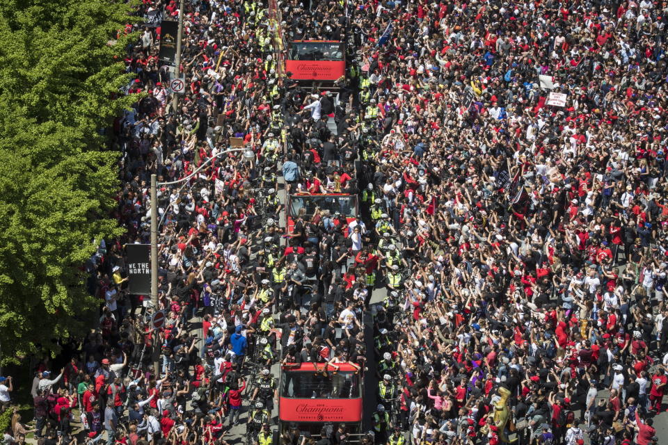 Members of the Toronto Raptors NBA basketball championship team ride on buses during a victory parade in Toronto, Monday, June 17, 2019. (Tijana Martin/The Canadian Press via AP)