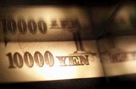 Light is cast on a Japanese 10,000 yen note as it's reflected in a plastic board in Tokyo, in this February 28, 2013 picture illustration. REUTERS/Shohei Miyano/File Photo