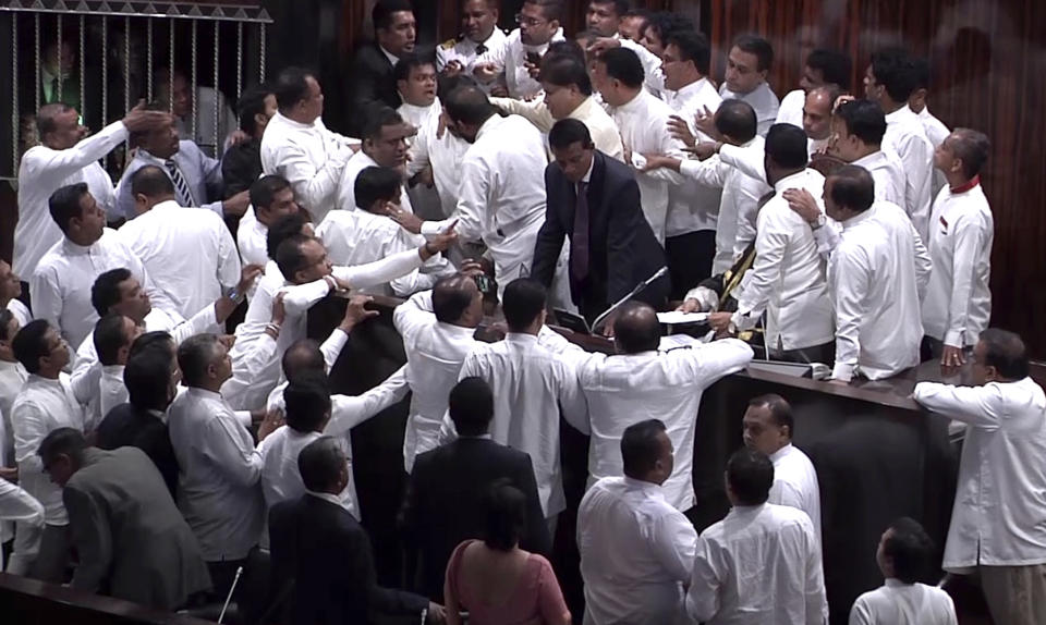 In this image made from video, Sri Lanka's lawmakers scuffle at the parliament in Colombo, Thursday, Nov. 15, 2018. Rival lawmakers have exchanged blows in Sri Lanka's Parliament as the disputed Prime Minister Mahinda Rajapaksa claimed the speaker had no authority to remove him from office by voice vote. (AP Photo)