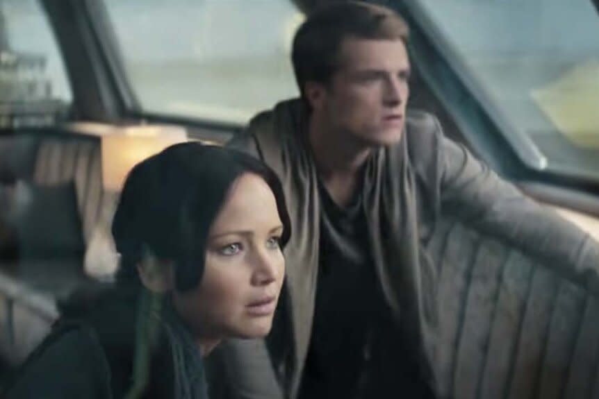 Katniss (Jennifer Lawrence) and Peeta (Josh Hutcherson) glance out a train window in The Hunger Games: Catching Fire (2013)