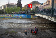 Paramedics attend a youth who fell to the Mapocho river from a bridge during a police charge on protesters in Santiago, Chile, Friday Sept.2, 2020. The incident unleashed a wave of criticism against police for the repression during demonstrations and the government repudiated the acts of violence condemning "categorically any action that violates human rights". The young man is in a hospital in serious but stable condition, according to the latest medical reports. (AP Photo/Aliosha Marquez Alvear)